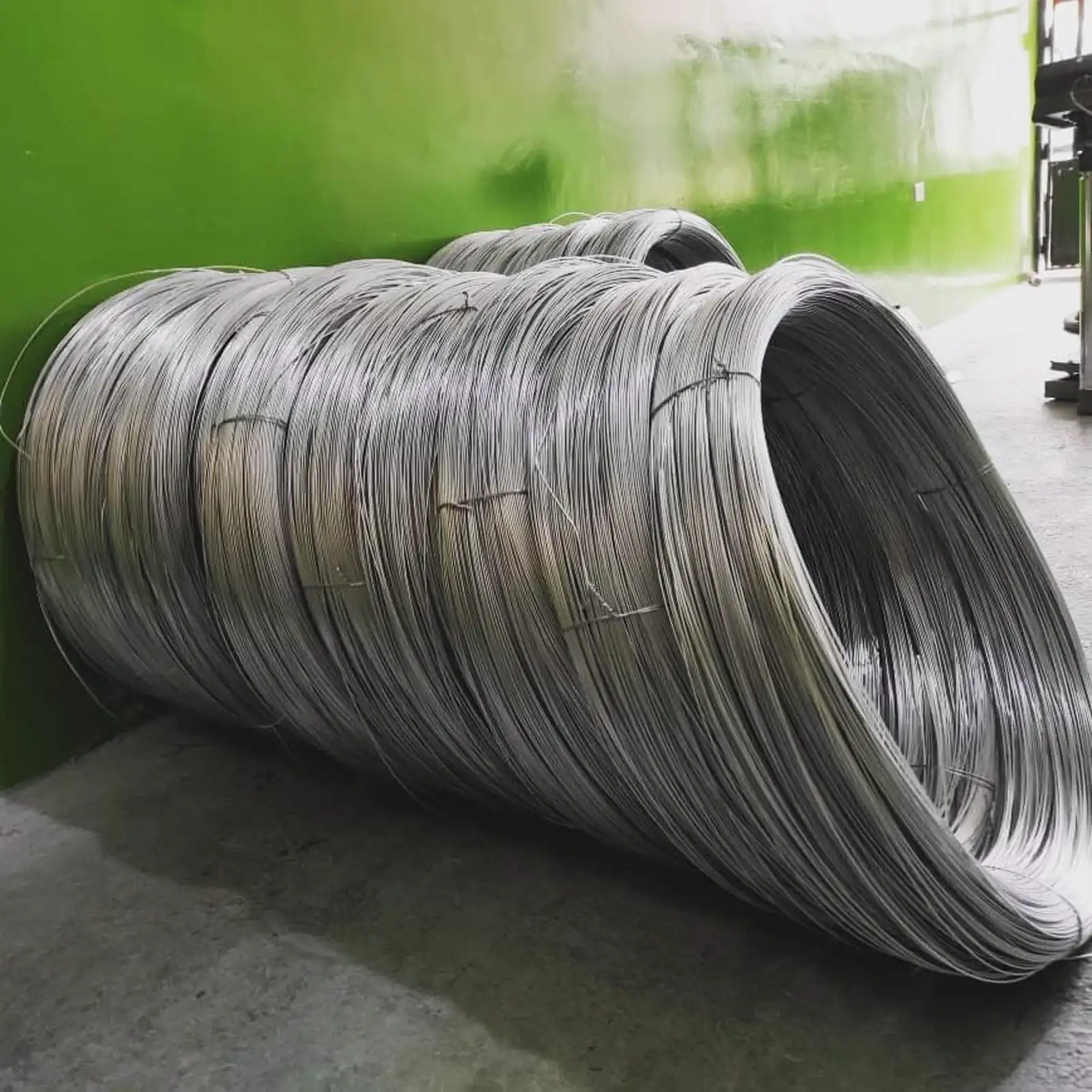 Rollos de alambre acerado apilados en bodega, listos para despacho
